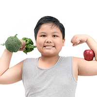 Obese fat boy holding a broccoli dumbbell and show muscle with apple isolated on white background, diet and exercise for good health concept