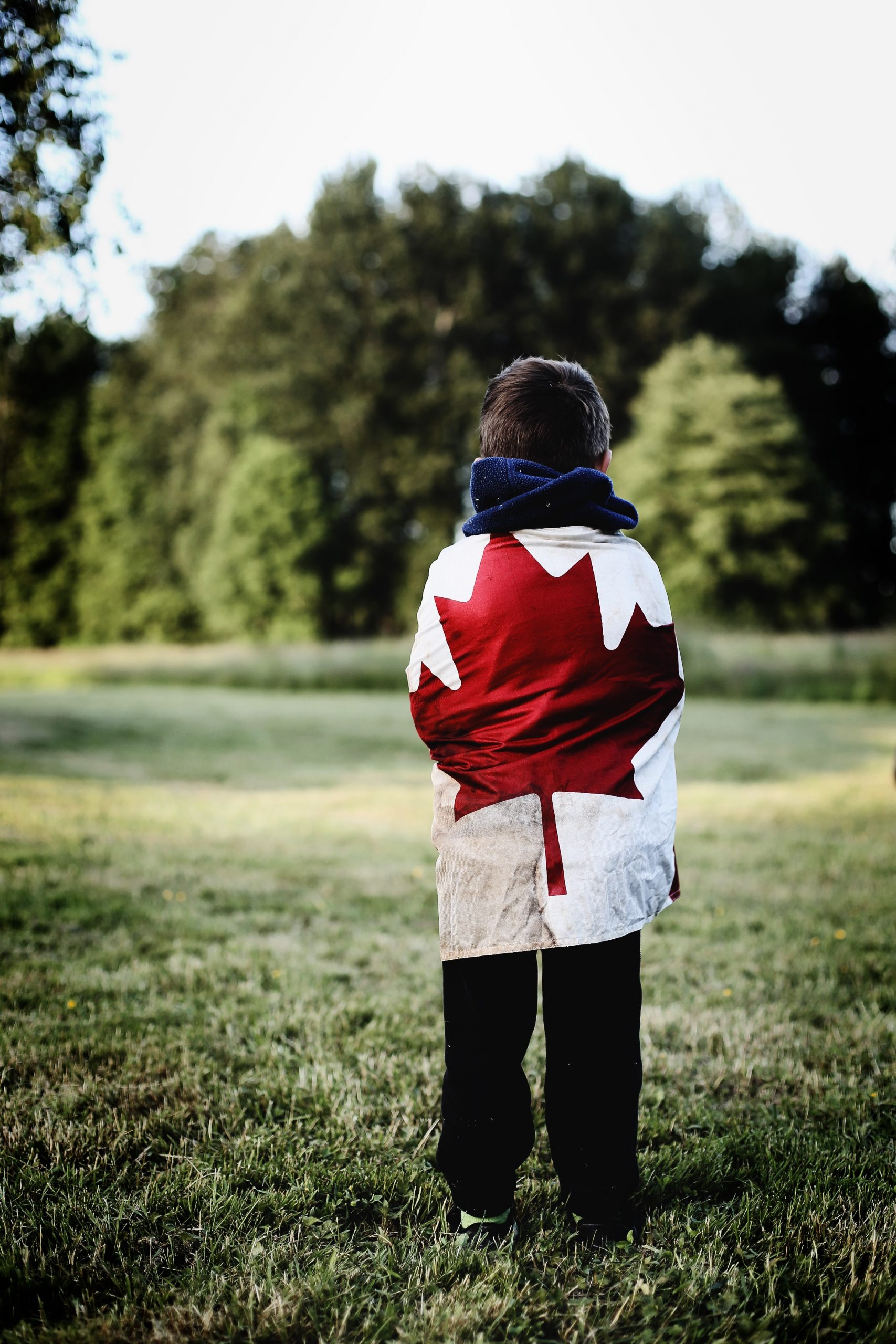 Youth wrapped in Canadian flag on the field