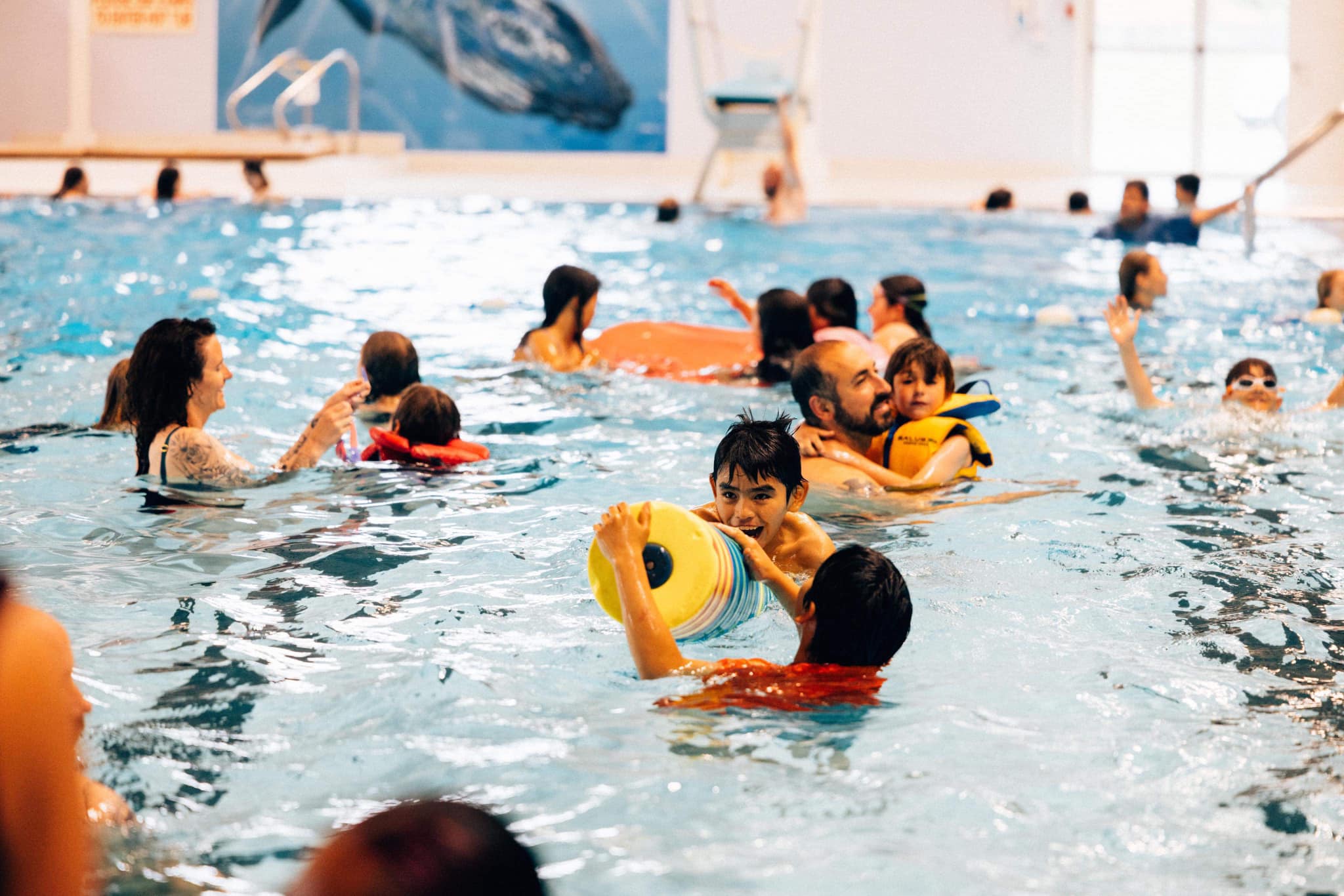 Families in a swimming pool in Port Hardy enjoying themselves with toys