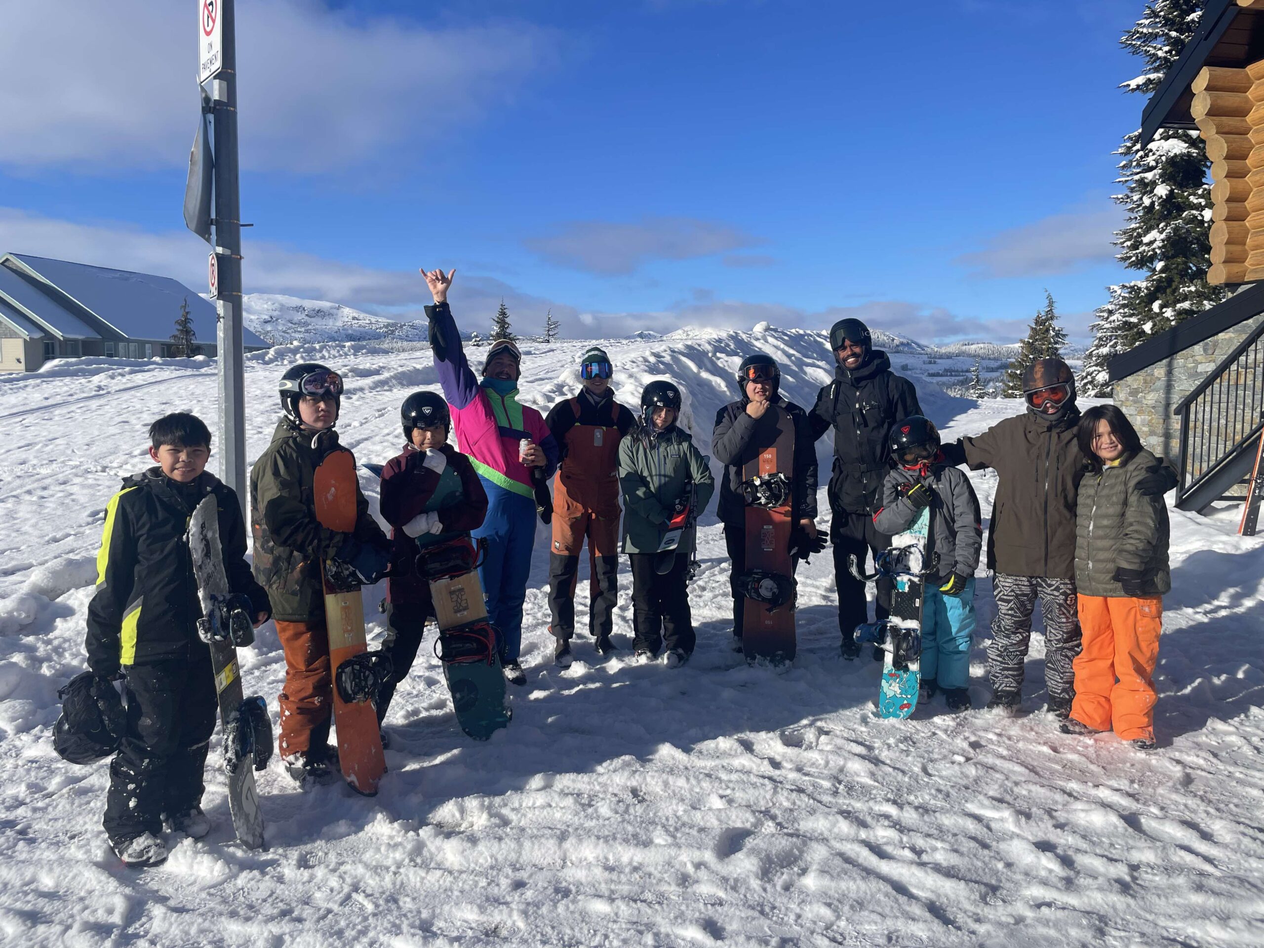 Group of youth from Tla-o-qui-aht-First-Nation on a mountain in snow gear