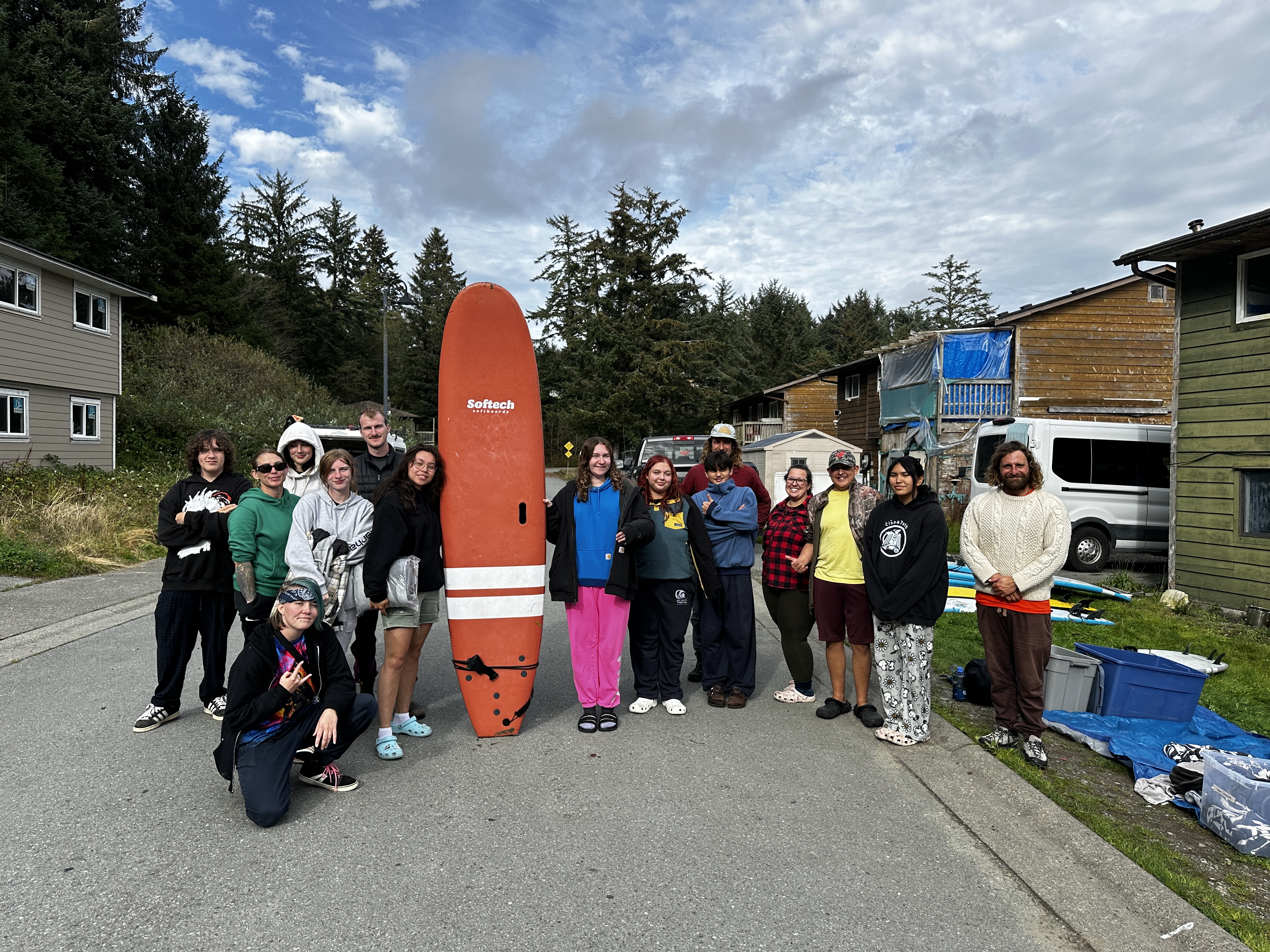 Group of youth from Tla-o-qui-aht-First-Nation with surf boards and surf instructor