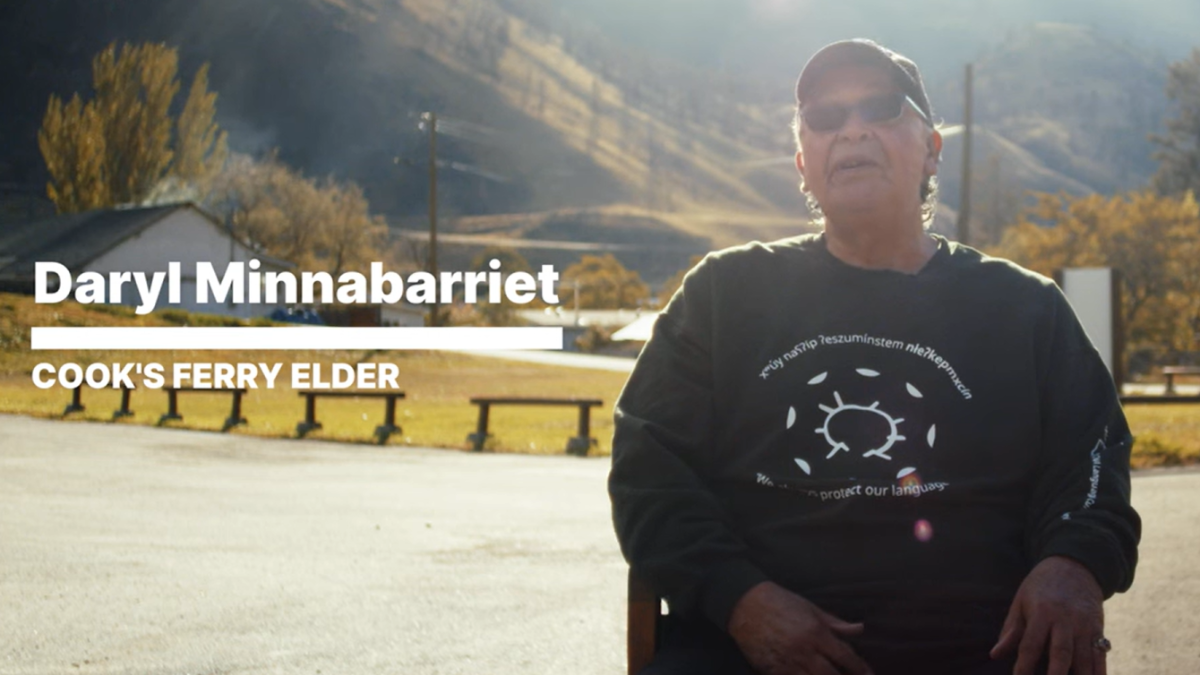 Cook's Ferry Elder Daryl Minnabarriet sitting in front of mountain on Cook's Ferry First Nation